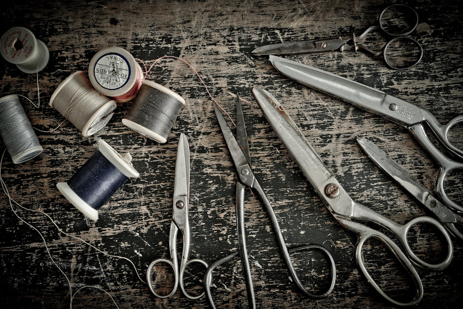 stainless steel scissors beside blue thread