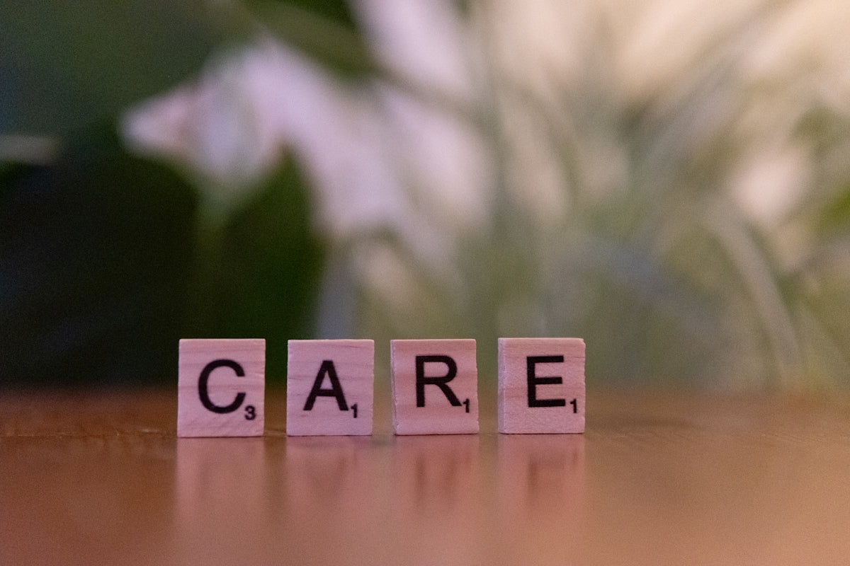 A wooden block spelling care on a table