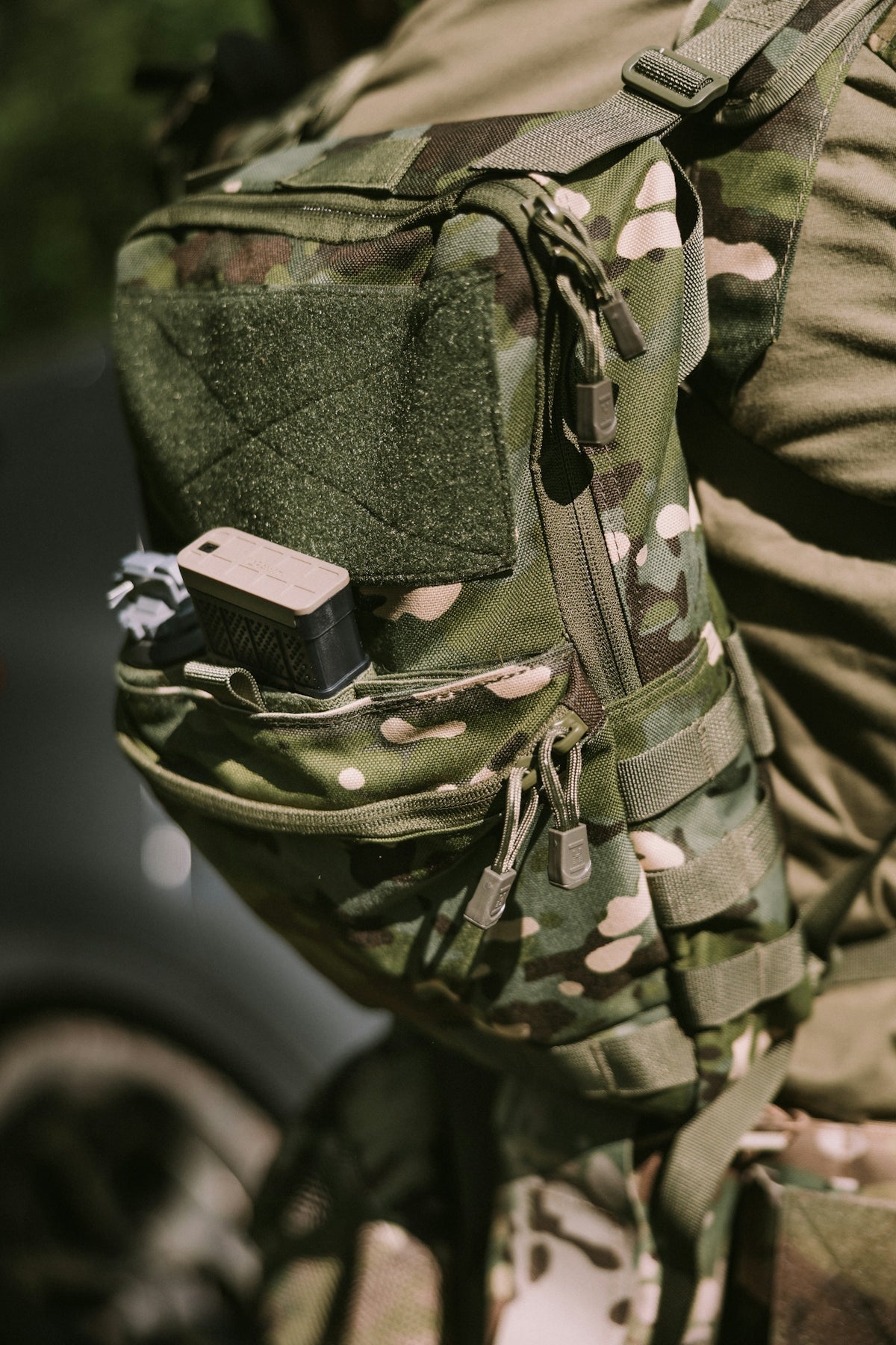 A military-style backpack with camouflage pattern.