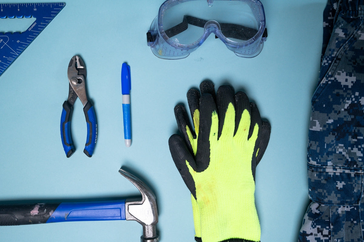 Tools and safety gear laid out on a blue surface.