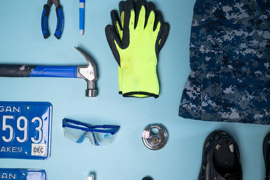 Tools and safety gear arranged on a blue surface.