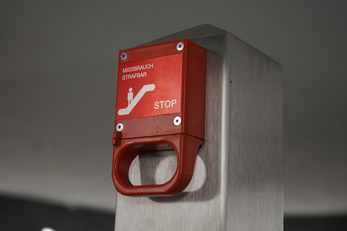 Red emergency stop button on metal pole