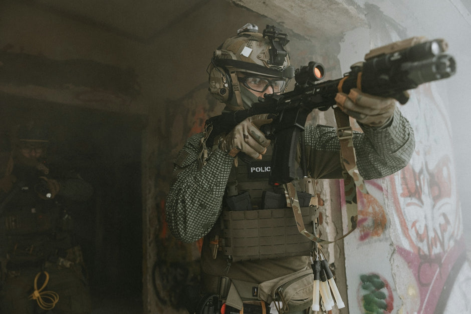 Soldier aiming rifle through doorway in urban environment