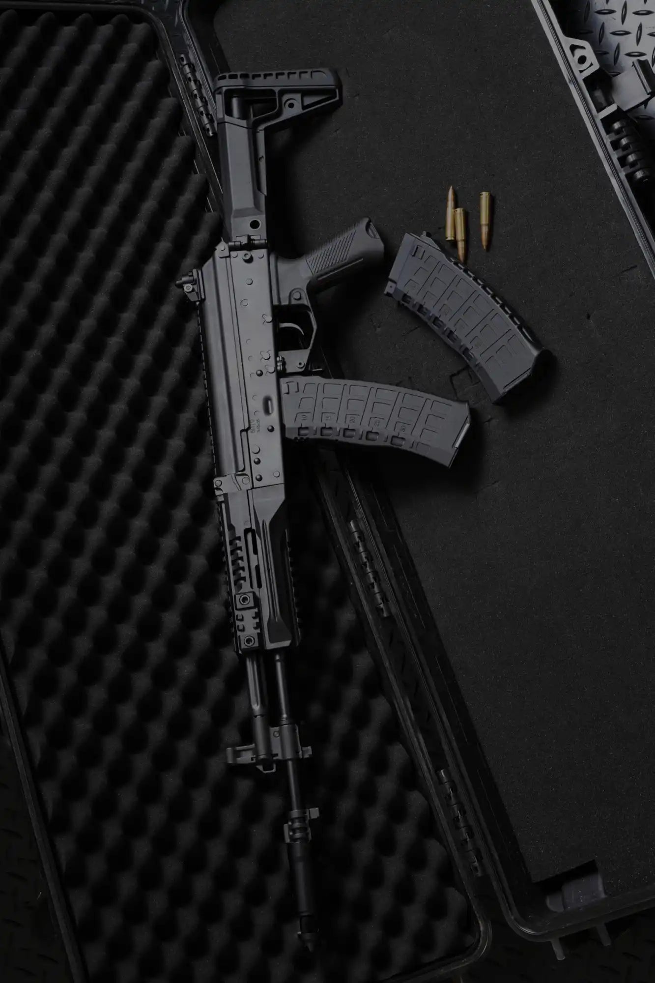 Black assault rifle with a loaded magazine and loose ammunition.